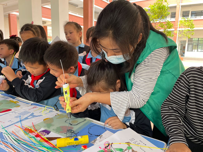 图6.工作人员引导学生体验3D打印.jpg